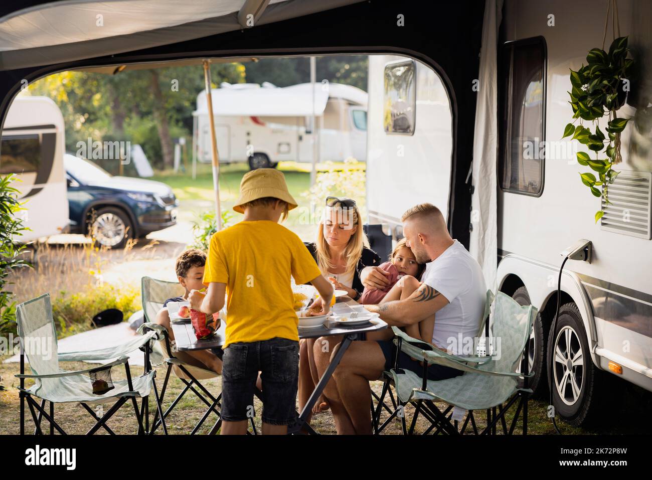 Family sitting at picnic table Stock Photo Alamy