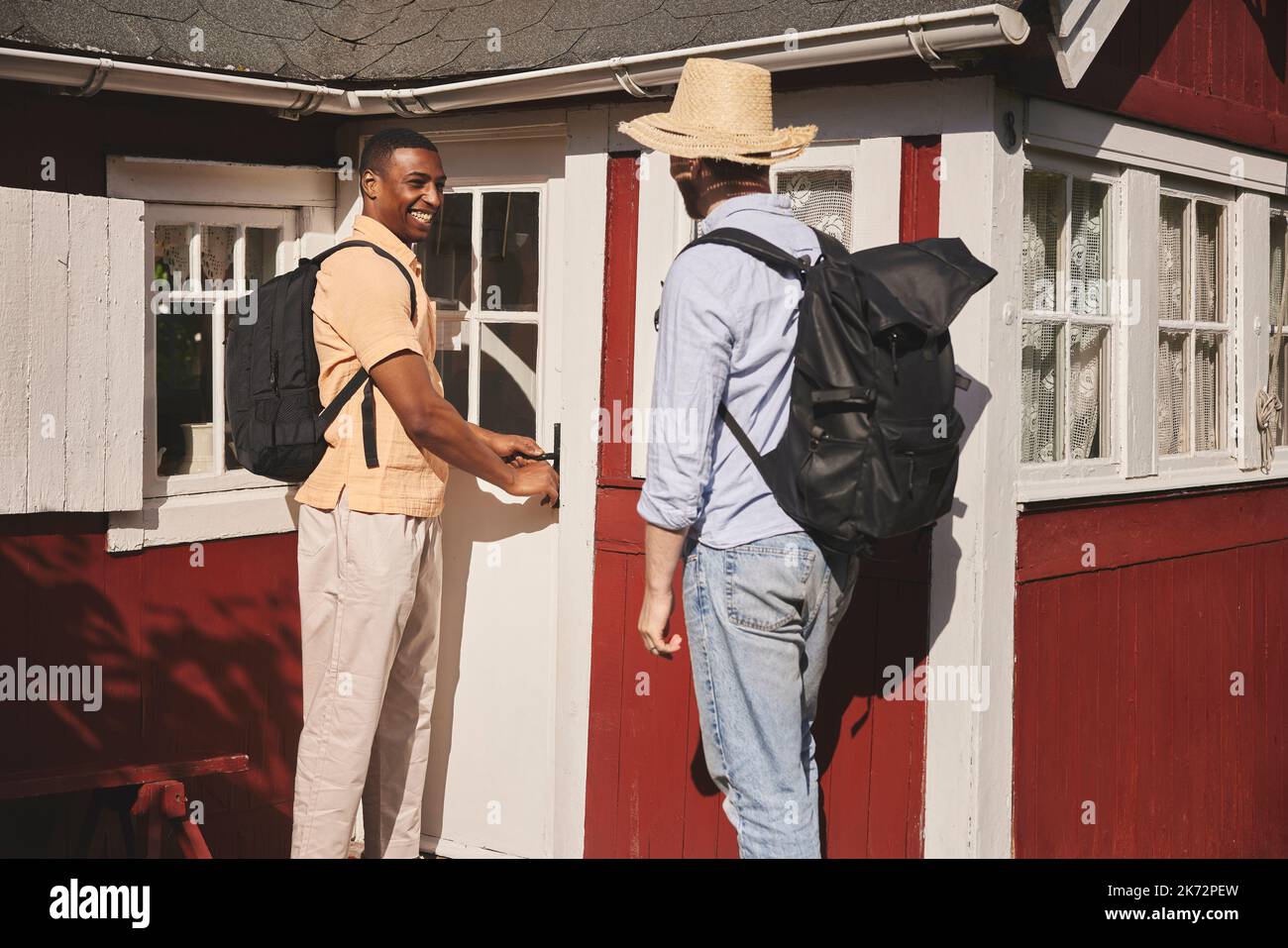 Young men standing in front of wooden house Stock Photo - Alamy