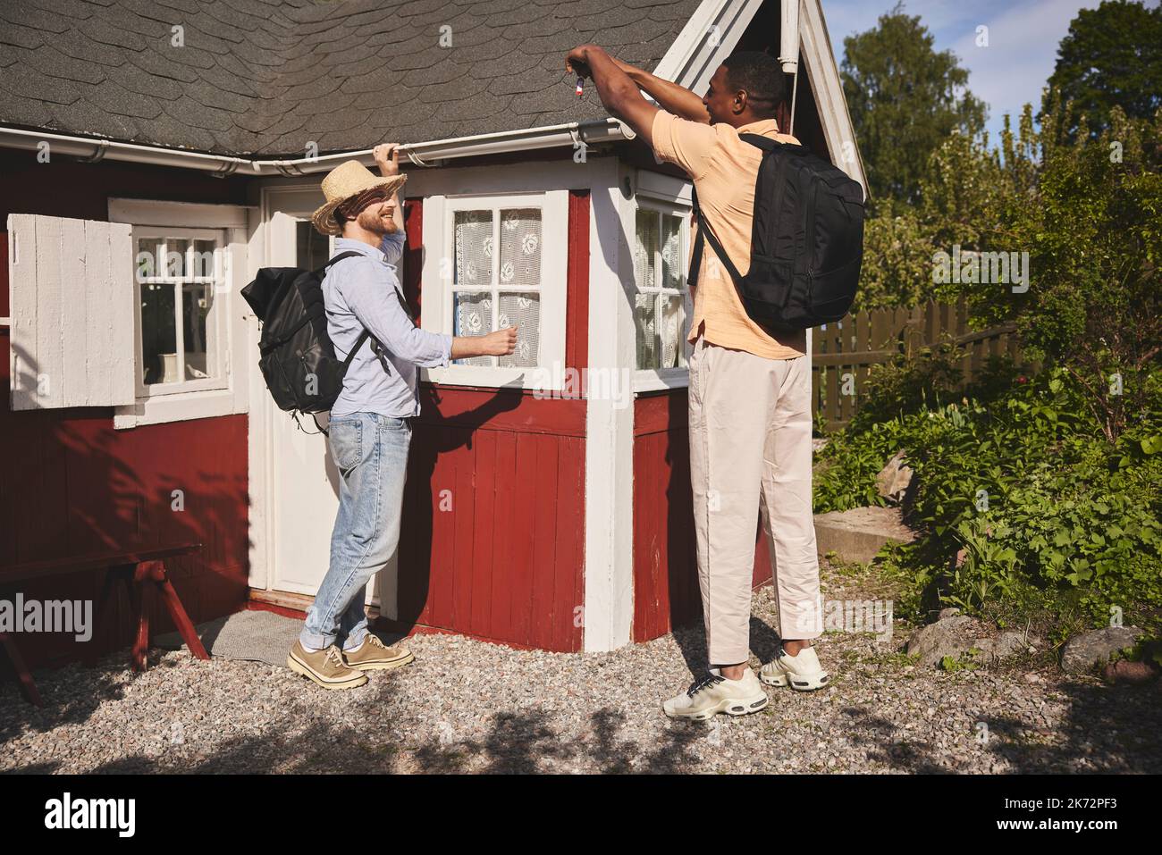 Young men standing in front of wooden house Stock Photo - Alamy