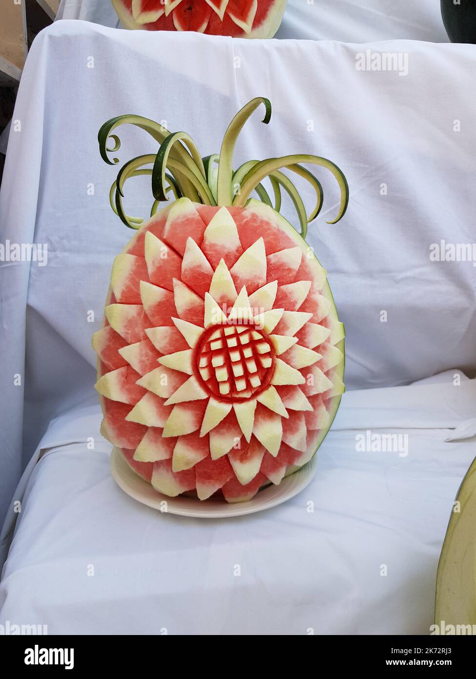 Large fresh watermelon with carved decorations on the counter. Decorative watermelon carving. Fruit cutting art Stock Photo