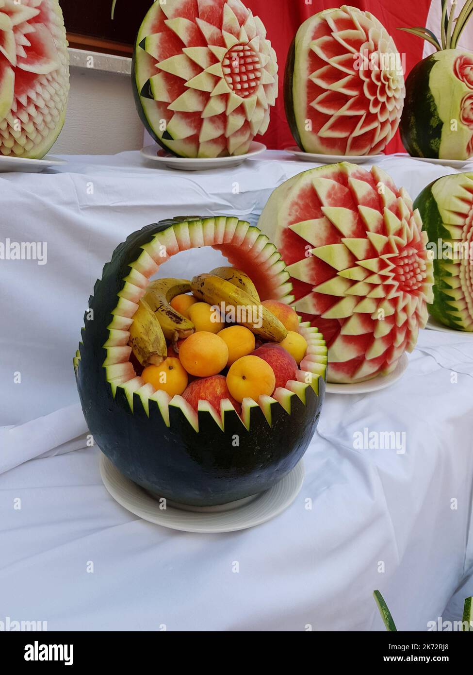 Large fresh watermelons with carved decorations on the counter. Decorative watermelon carving. Fruit cutting art Stock Photo