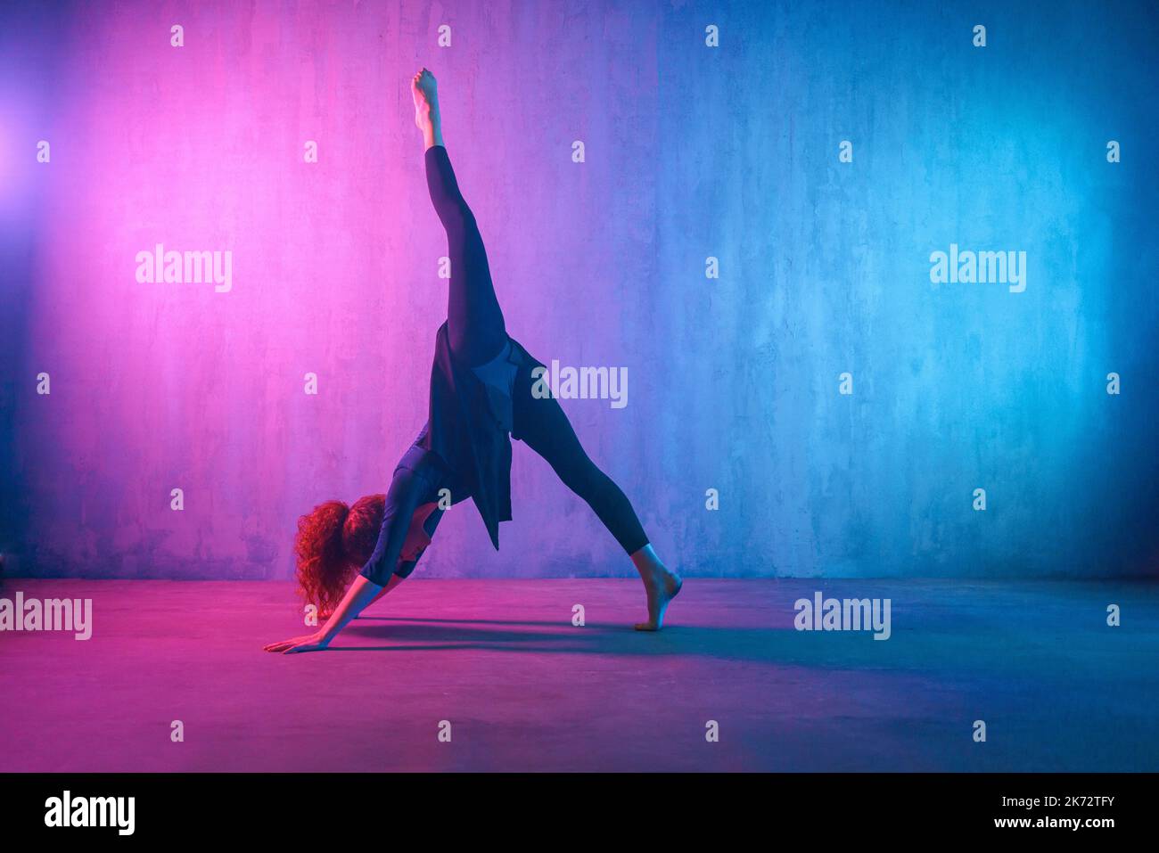 Modern dance girl dancer dancing in neon light doing gymnastic