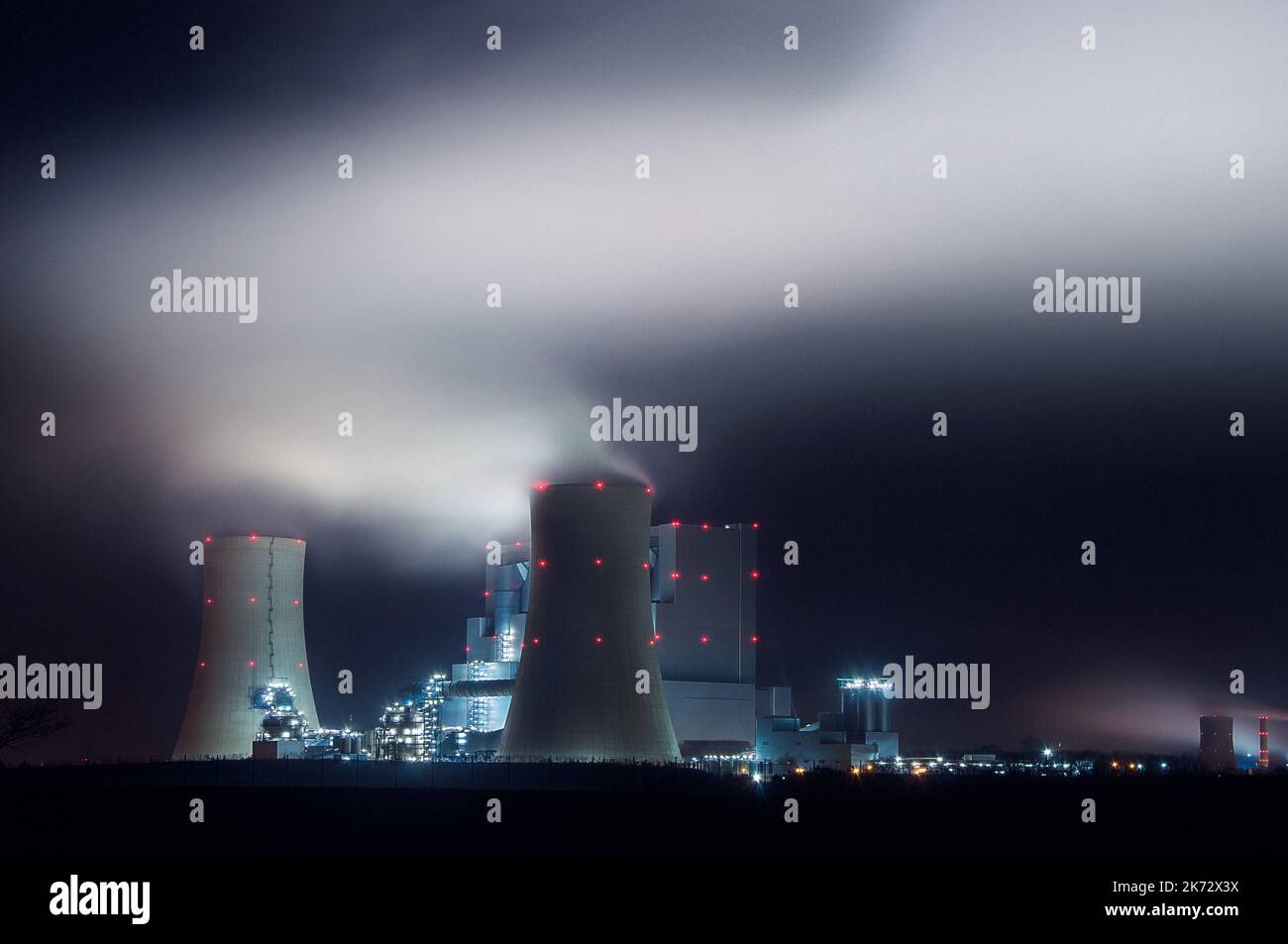 Panorama of coal power plant at night with smoke from cooling towers Stock Photo