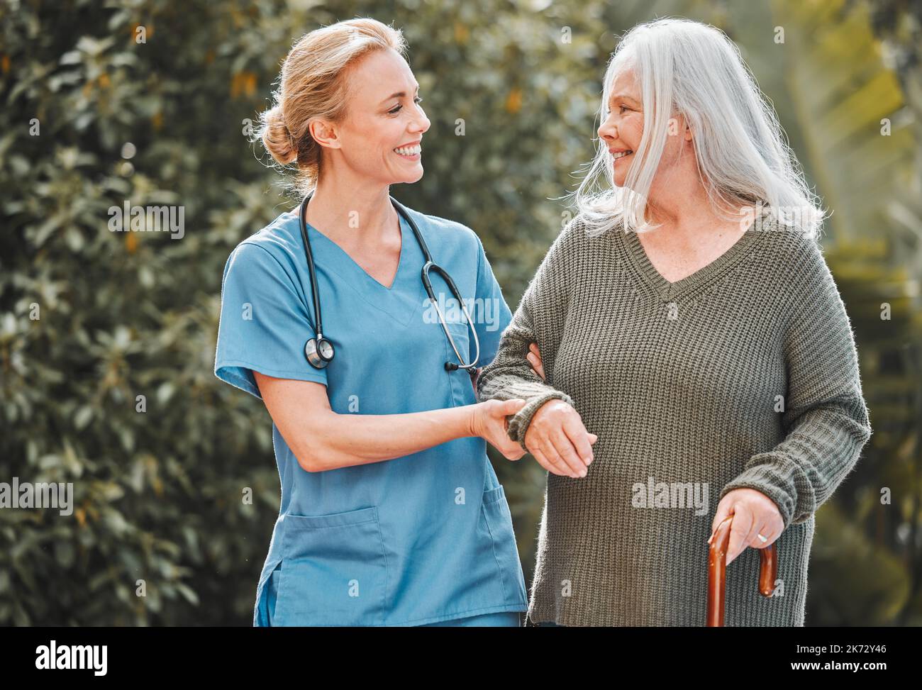 Its a wonderful day for a walk. a female nurse getting fresh air with her elderly patient. Stock Photo