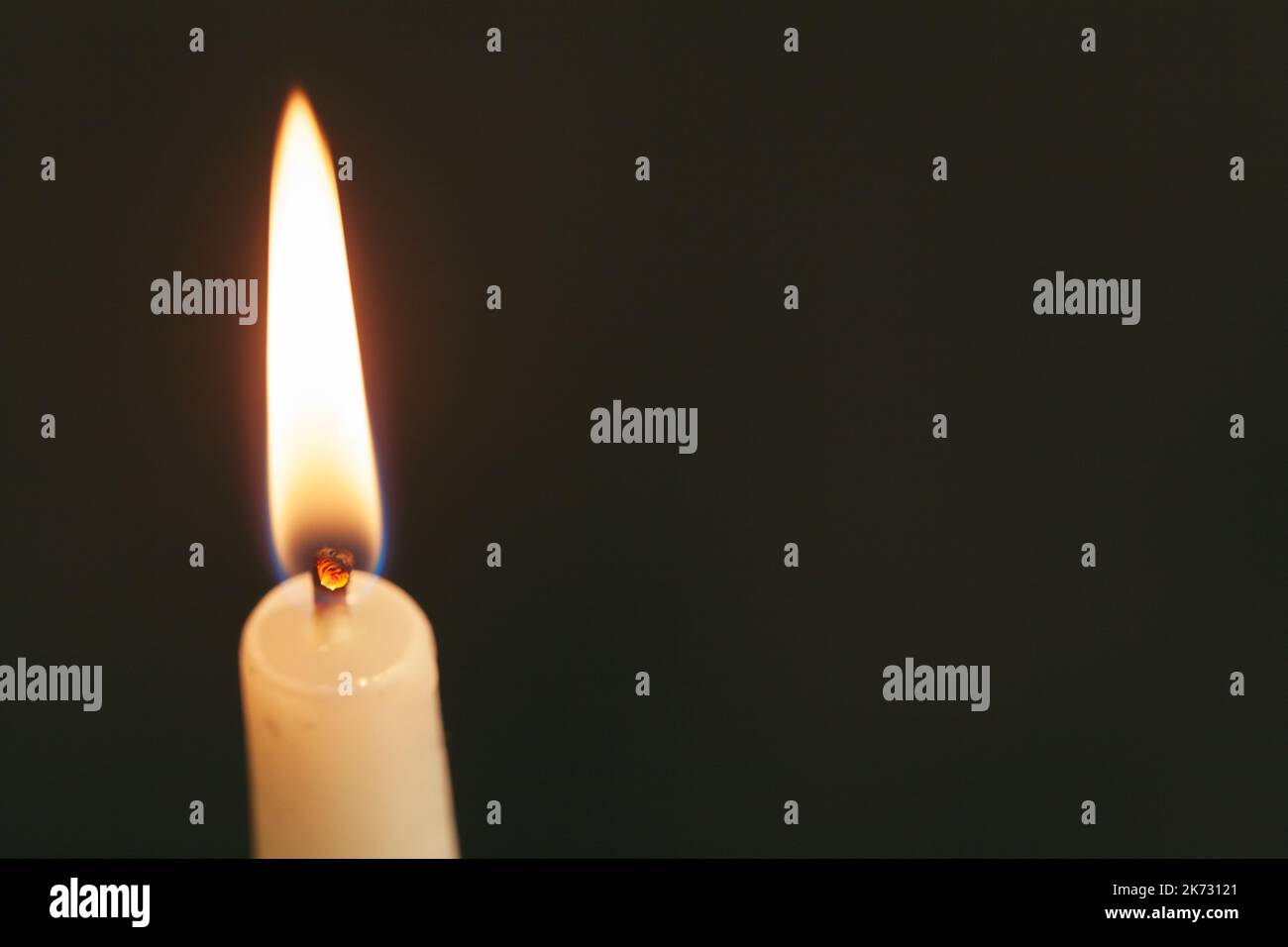 A single burning candle isolated with black background Stock Photo - Alamy