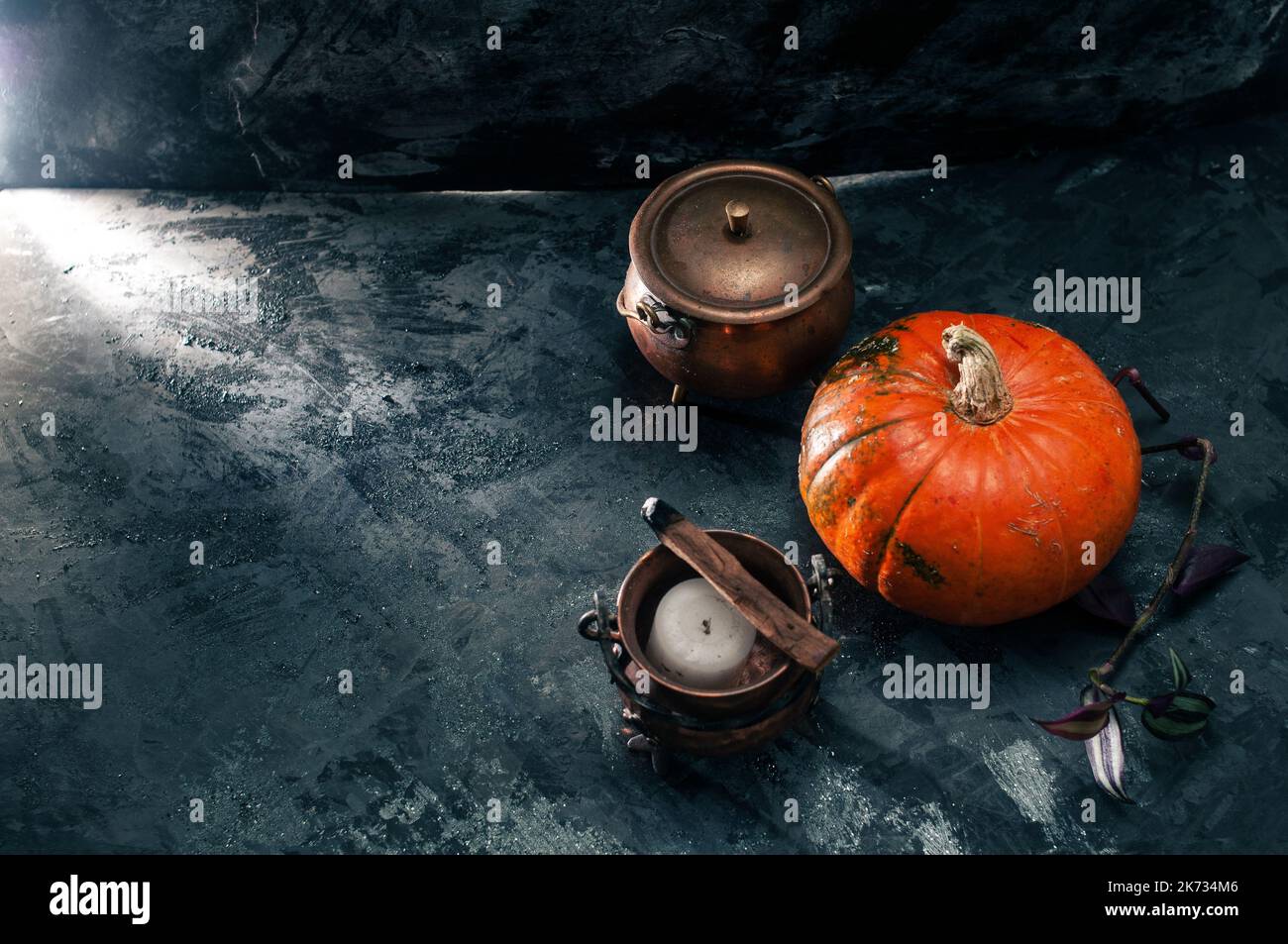One pumpkin squash and copper or brass witch pots with candles and palo