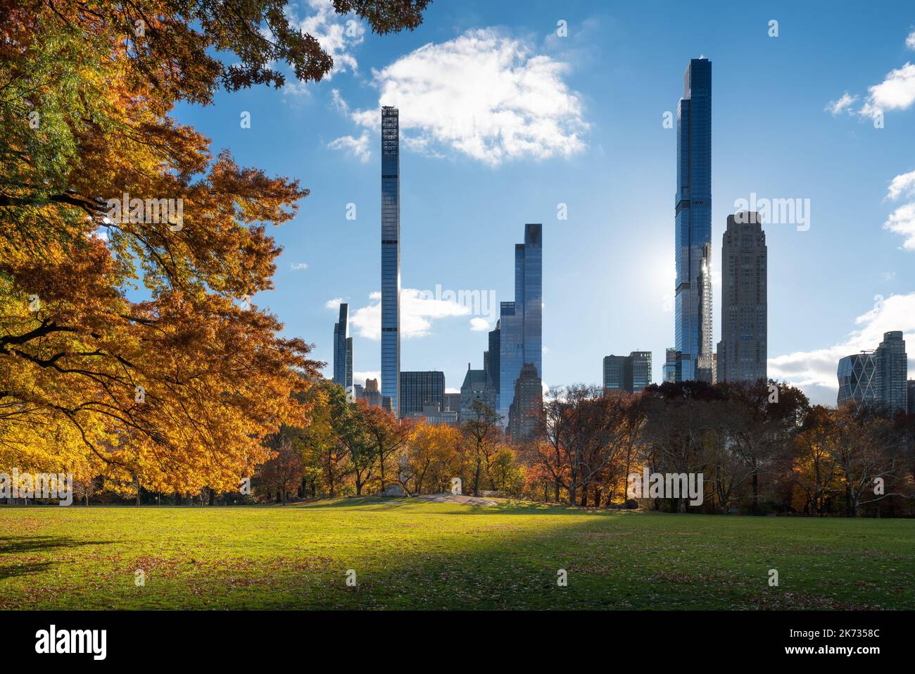 Central Park Sheep Meadow lawn in Fall with Billionaires Row skyscrapers. Midtown Manhattan, New York City Stock Photo