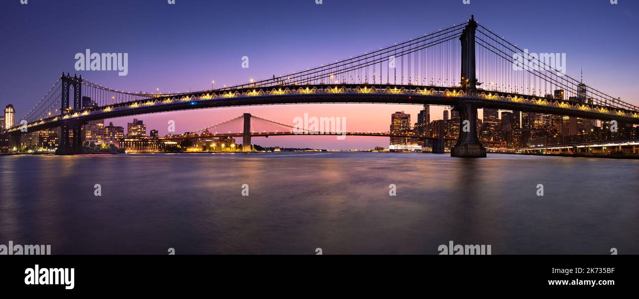 Manhattan Bridge and Brooklyn Bridge and East River in evening. View of DUMBO in Brooklyn and Lower Manhattan. New York City Stock Photo