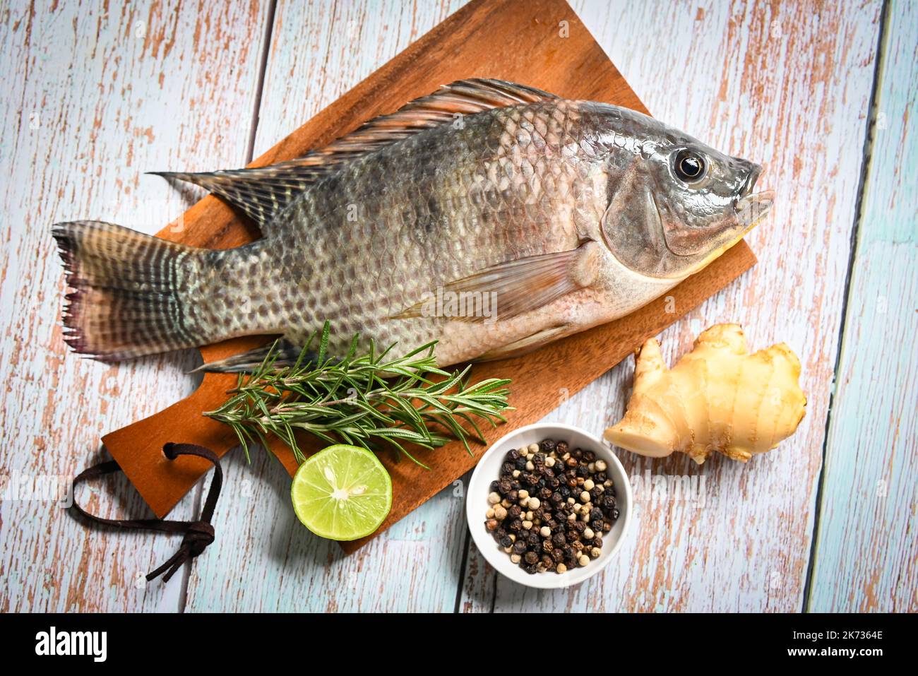 Tilapia with spice rosemary lemon lime ginger pepper on table