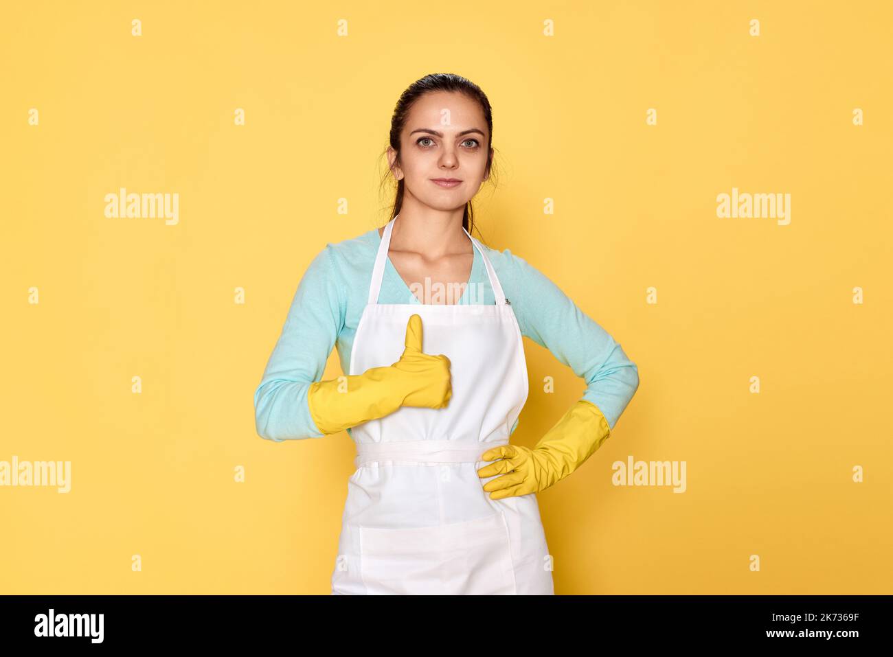 woman in gloves and cleaner apron showing ok sign Stock Photo - Alamy