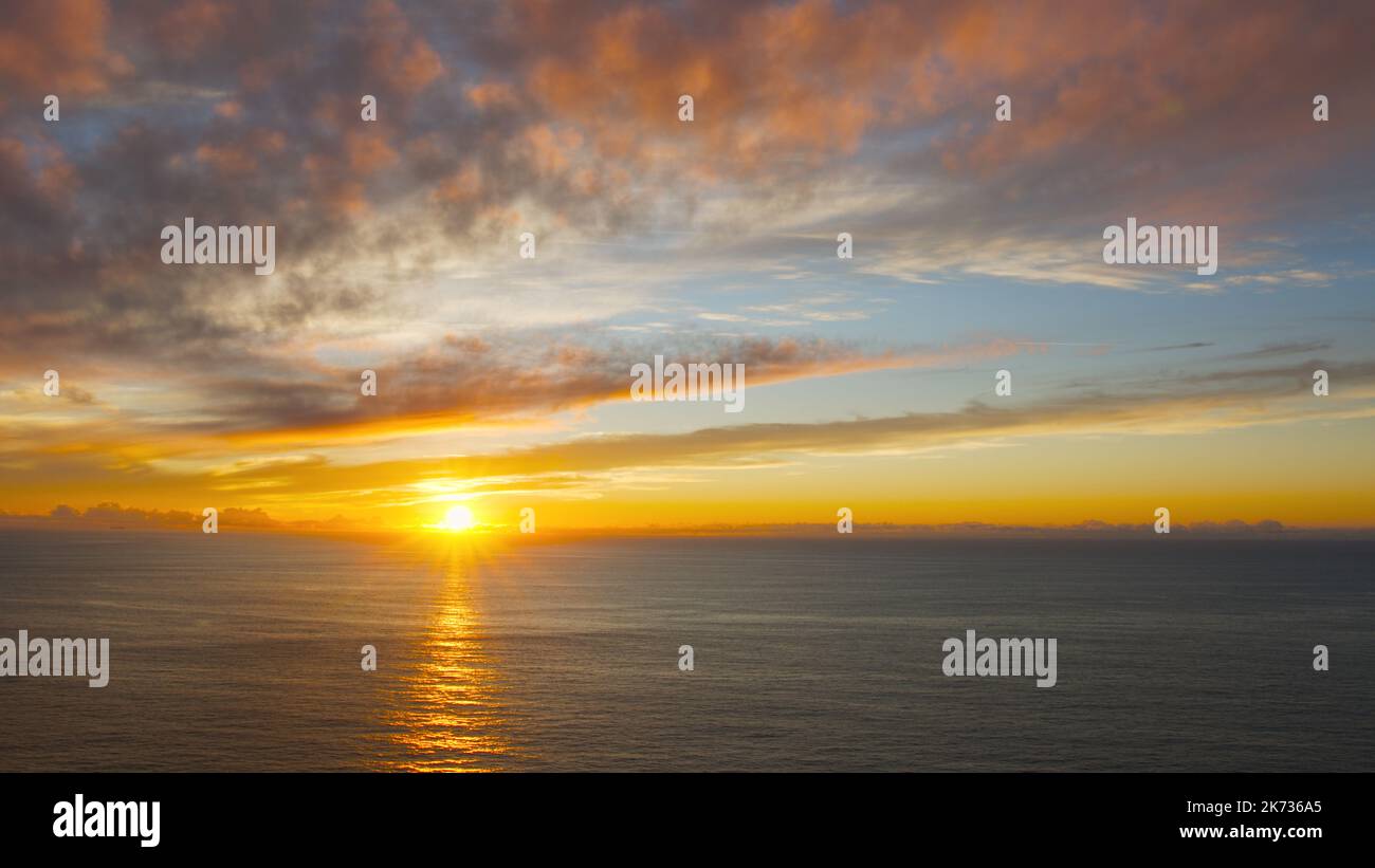 Breathtaking sunset in the calm ocean at the Cabo da Roca, Portugal. Stock Photo