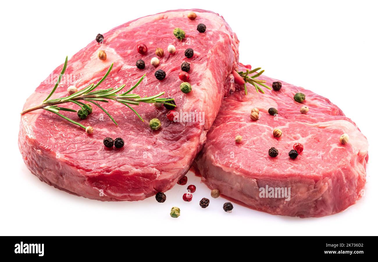 Two fresh ribeye steaks with peppercorn and rosemary isolated on white background. Closeup. Stock Photo