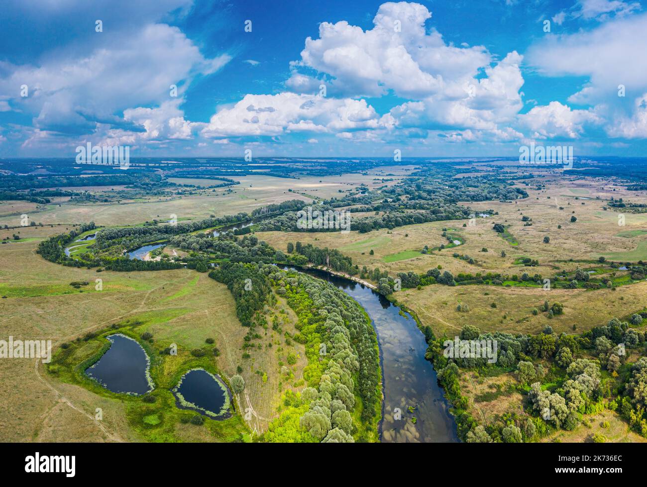 Beautiful Ukrainian nature background. Drone view on riverbank of the Seym river and amazing cloudscape over it. Summertime. Stock Photo