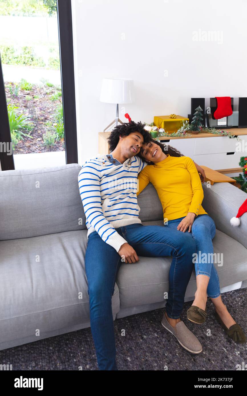 Happy african american couple sitting on sofa in living room and ...