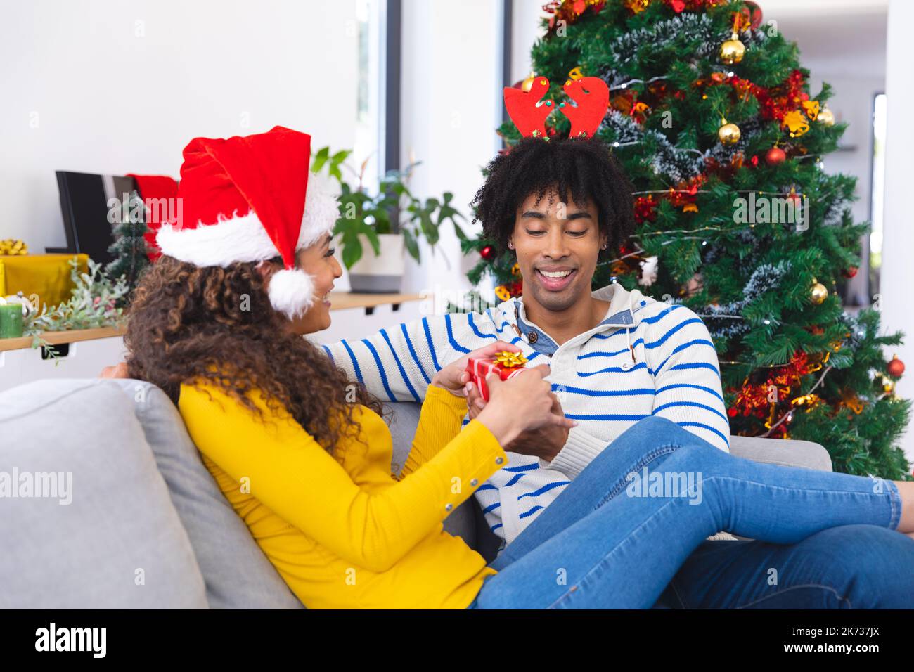 Happy african american couple sitting on sofa in living room and ...