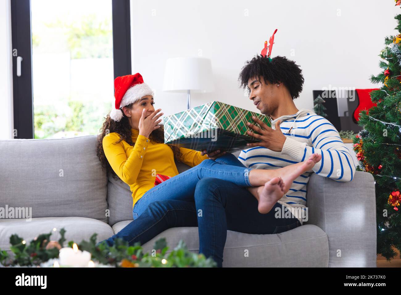 Happy african american couple sitting on sofa in living room and ...