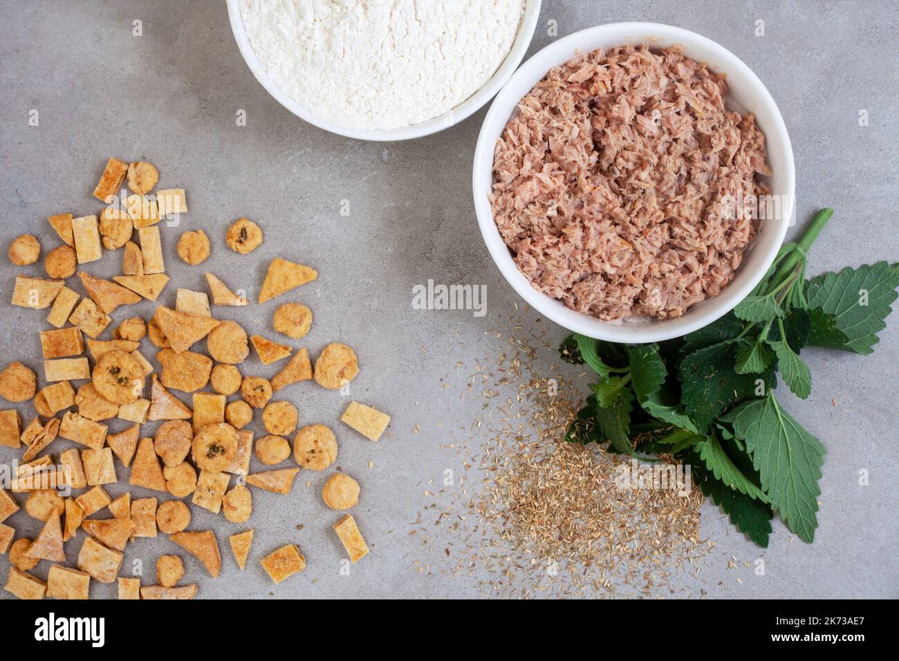 Homemade special tuna cat treats on mottled grey with ingredients and