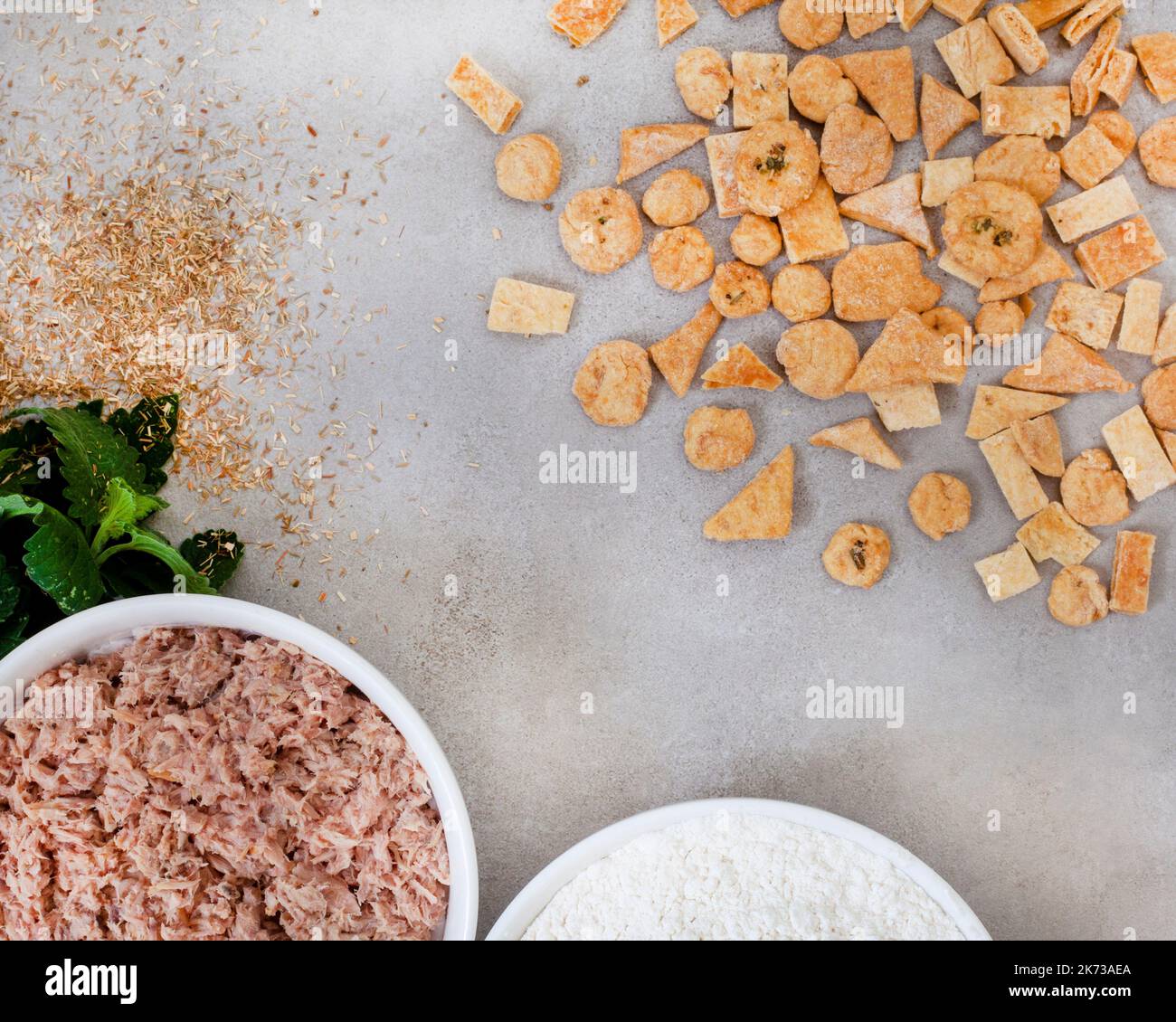 Homemade special tuna cat treats on mottled grey with ingredients and