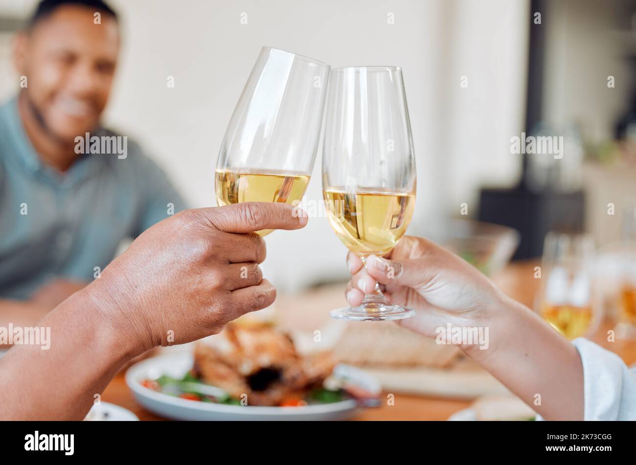 Lets toast to life. two unrecognizable people toasting with wine glasses at home. Stock Photo