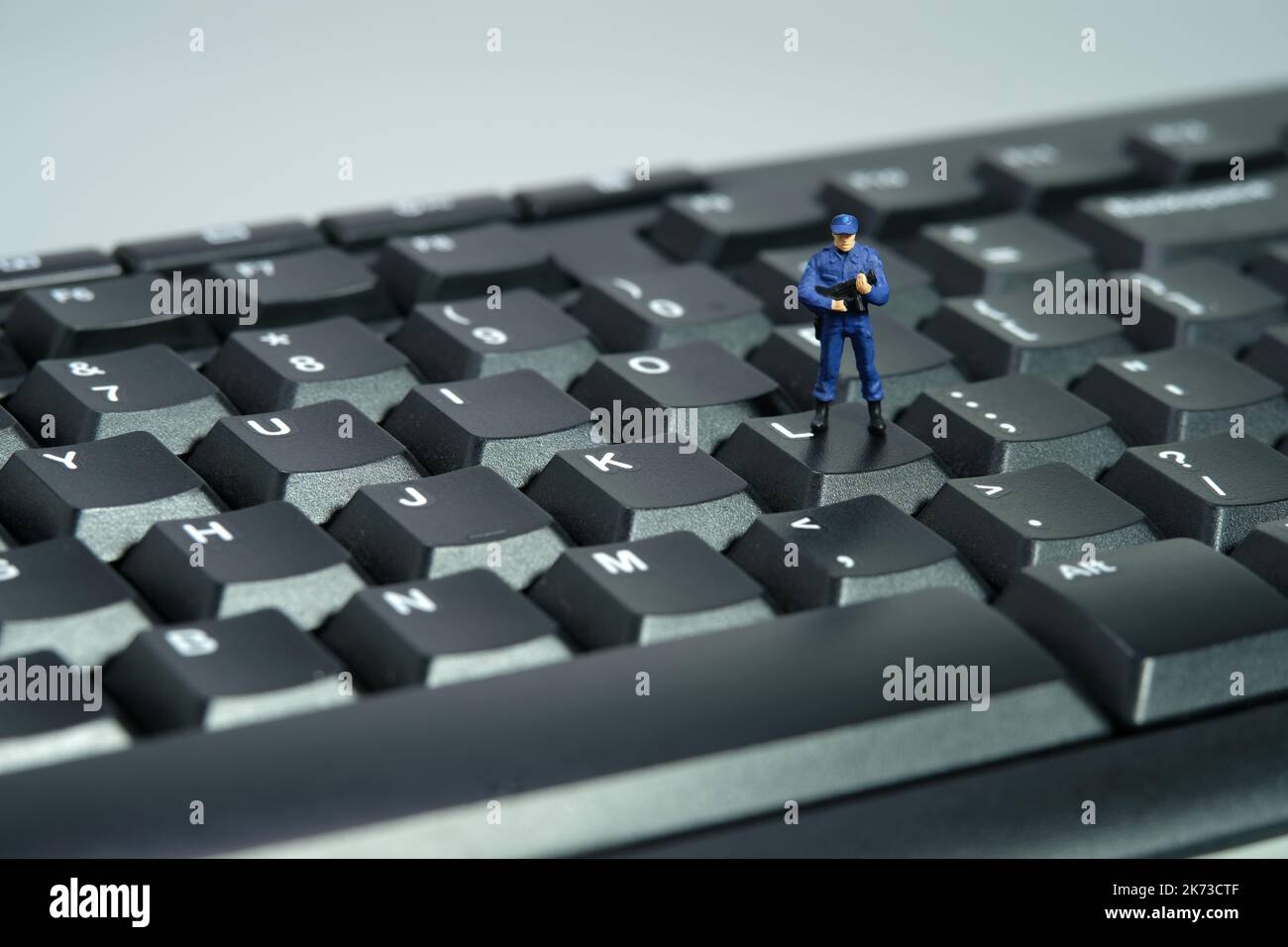 Miniature people toy figure photography. Data input privacy concept. A security officer standing above keyboard. Isolated on white background. Image p Stock Photo