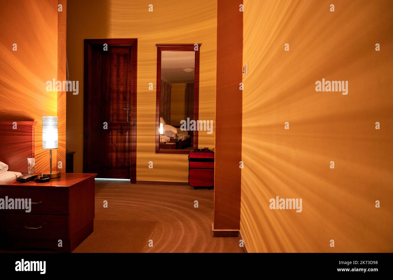 orange coloured hotel room lightened by a sensational  bedside lamp in Slovakia Stock Photo