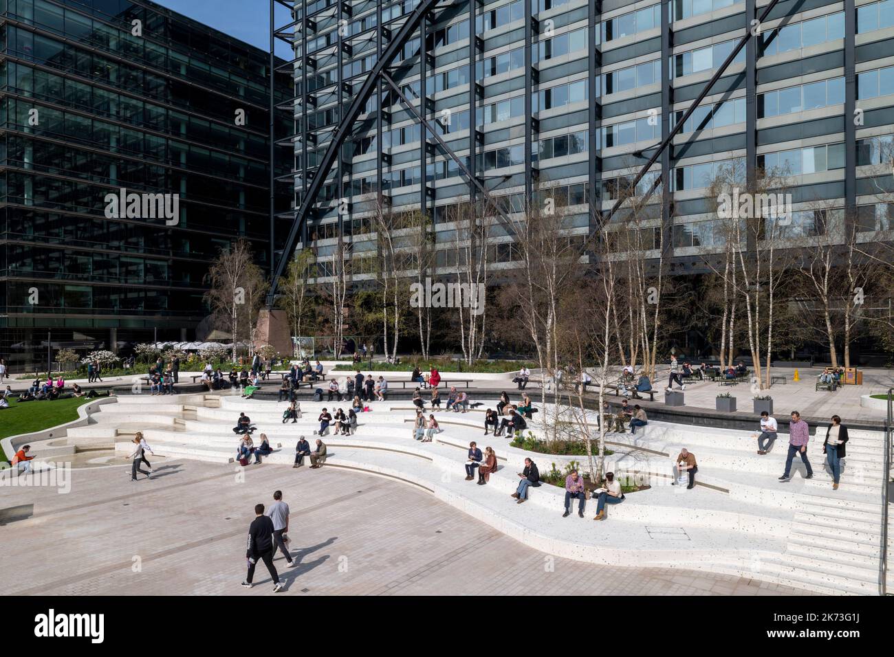 Wide view across square with informal seating. Exchange Square, London, United Kingdom. Architect: DSDHA, 2022. Stock Photo
