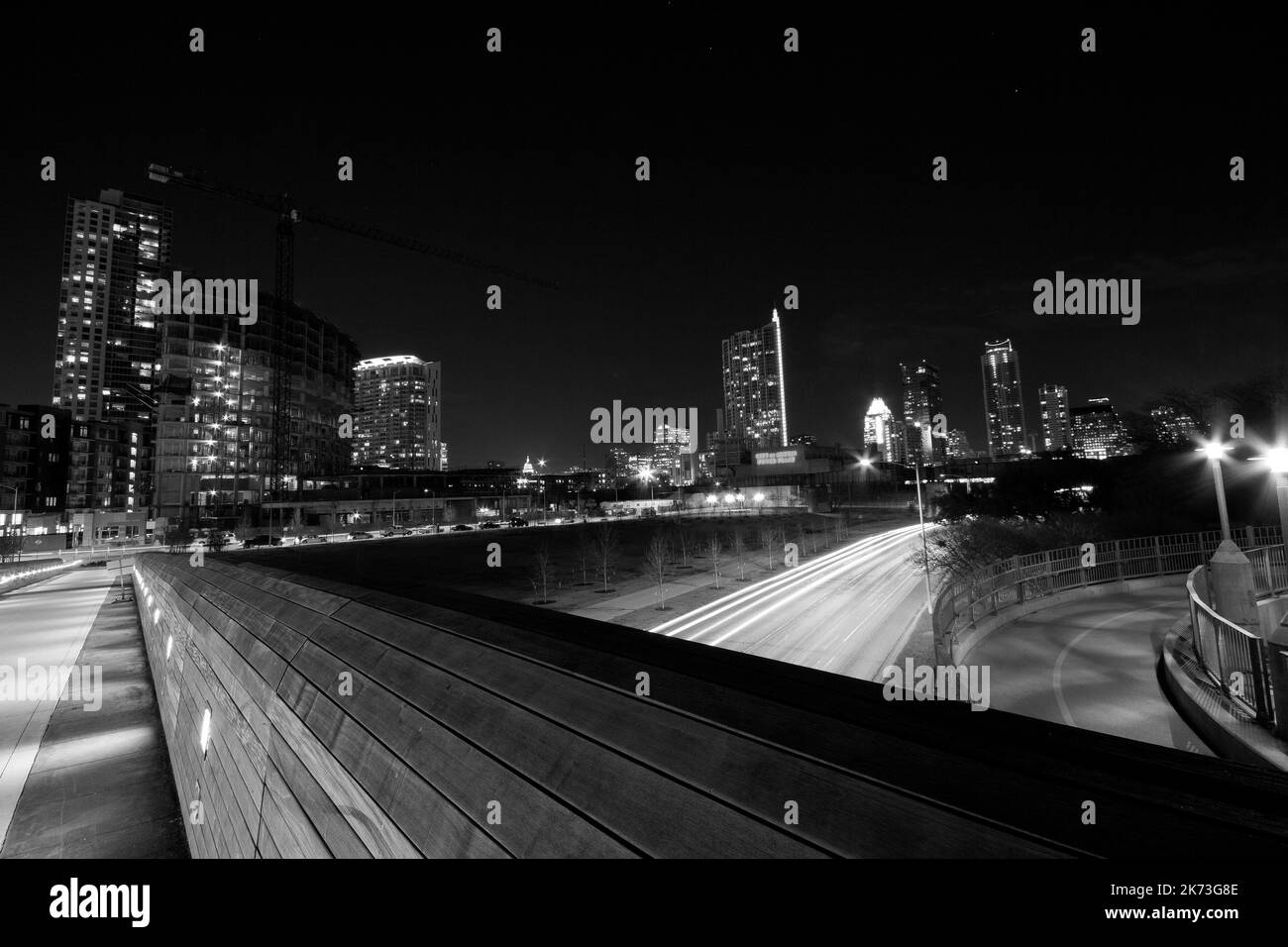 A long exposure grayscale of a night street traffic lights in Austin
