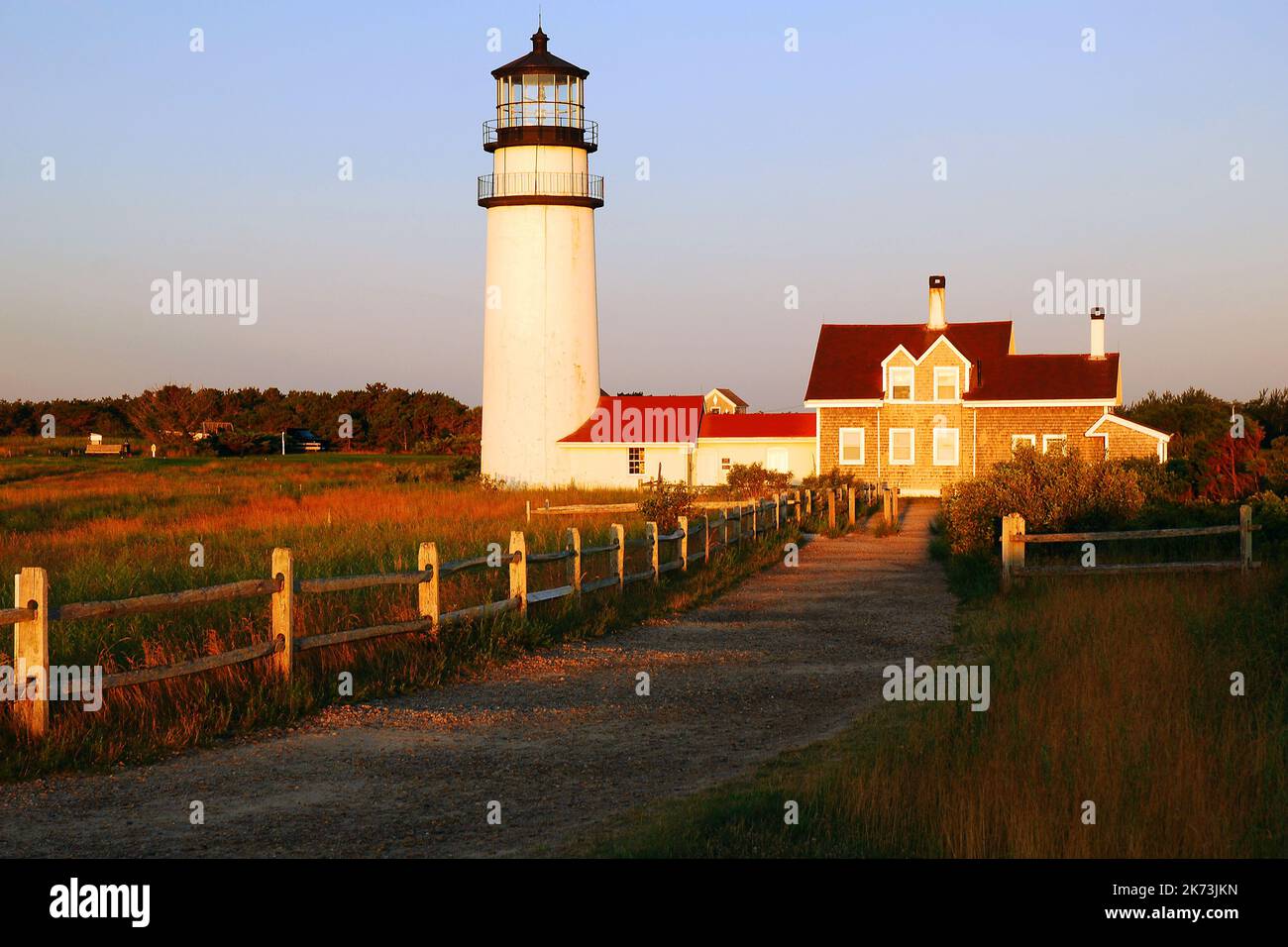 A gravel path and split rail fence leads to the North Truro Lighthouse, located on Cape Cod, near Provincetown Stock Photo