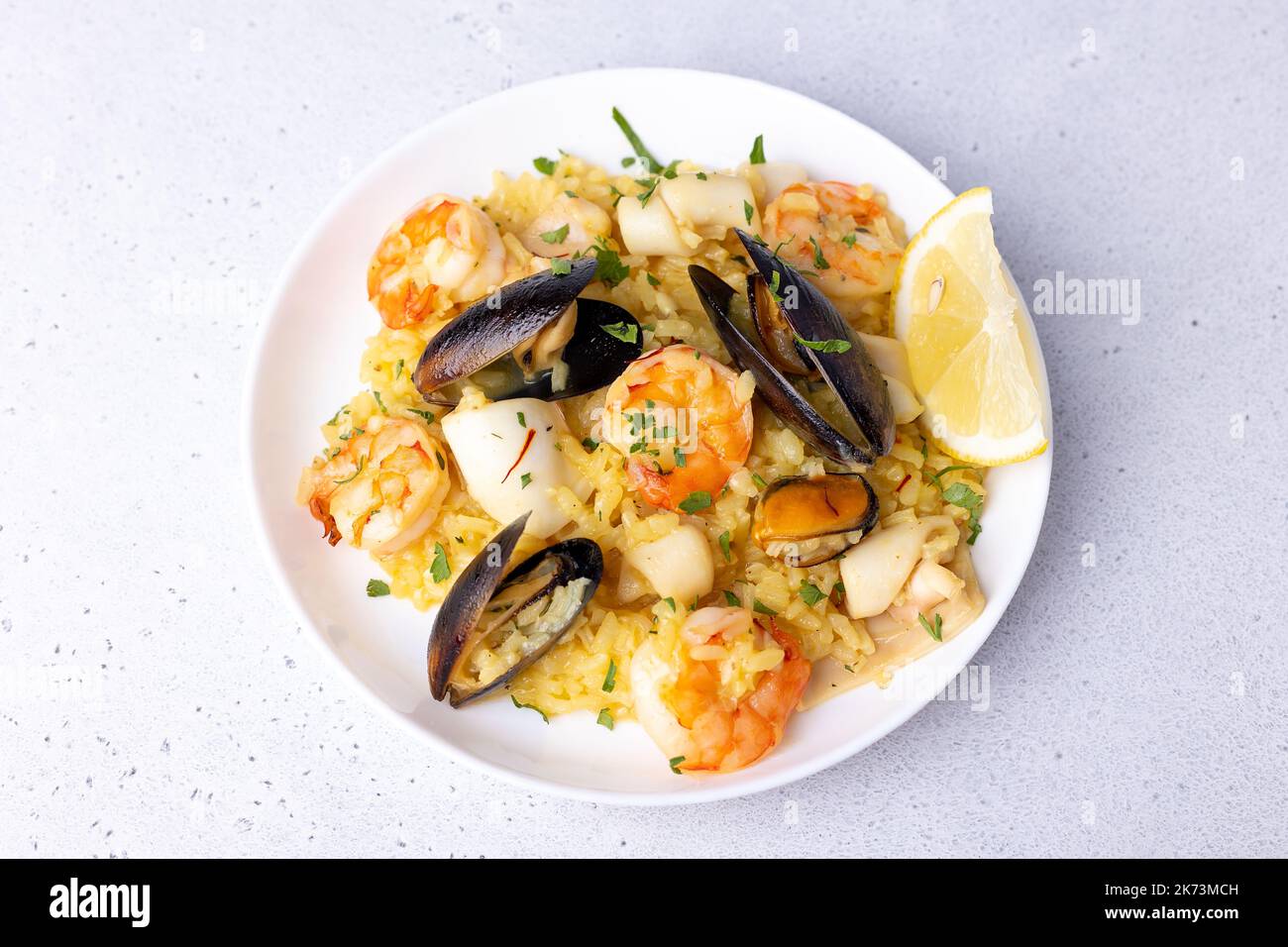 Seafood risotto with saffron, parsley and lemon. Arborio rice with