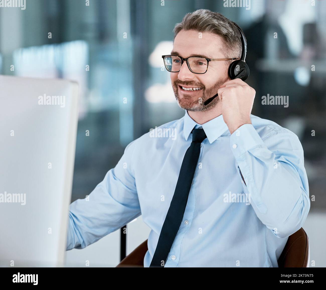 Ill setup your profile with us right away. a mature call centre agent working on a computer in an office. Stock Photo