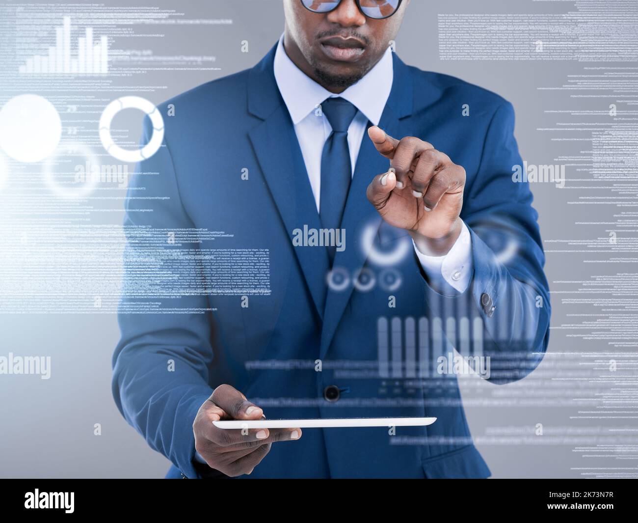 All the data he needs at the touch of a button. an unrecognizable businessman using his tablet to open a virtual interface in studio against a grey Stock Photo