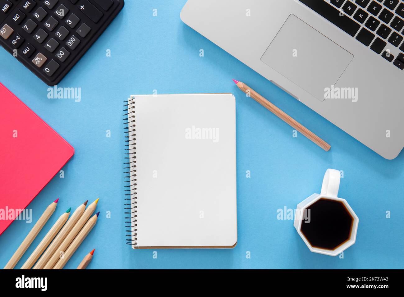 Flat lay, notepad, laptop and stationery on blue background. Stock Photo