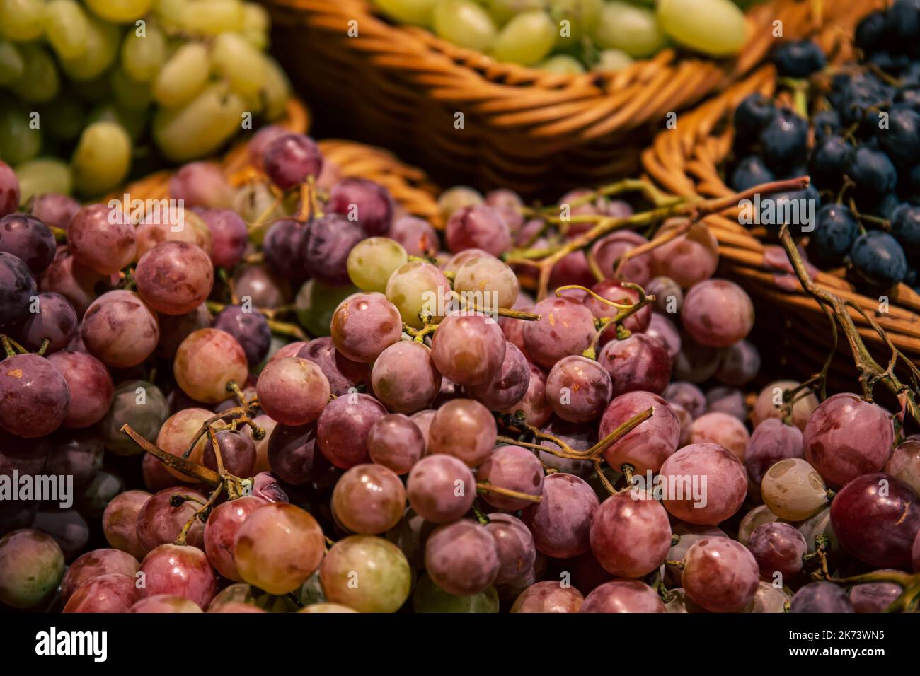 Baskets with different types of grapes on a supermarket showcase Stock