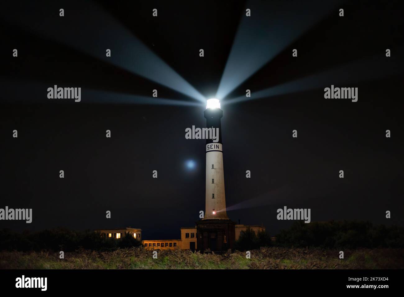 The tall and powerful Sein island lighthouse at night Stock Photo