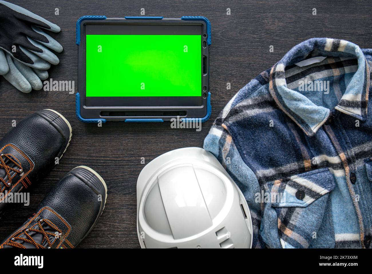 Digital tablet with layout and worker clothes, top view. Stock Photo