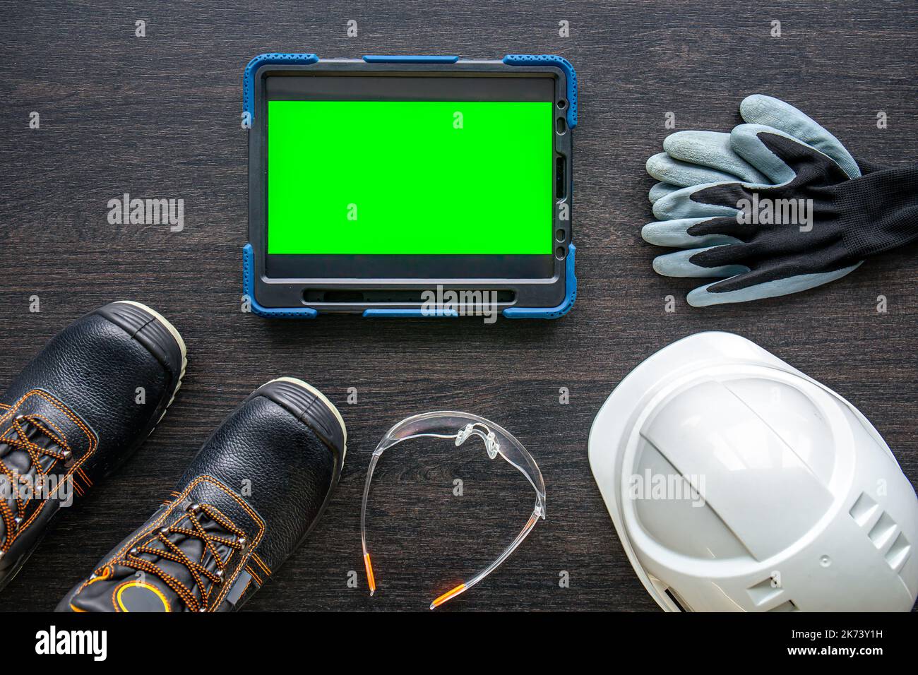 Digital tablet with layout and worker clothes, top view. Stock Photo