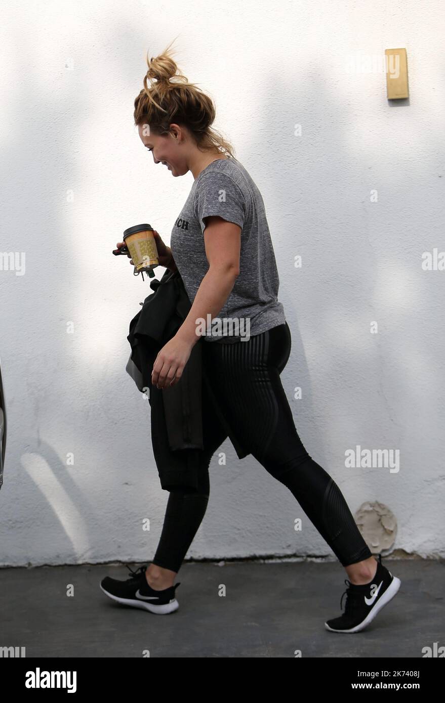 Hilary Duff wears a white top and green leggings while out running errands  in Los Angeles