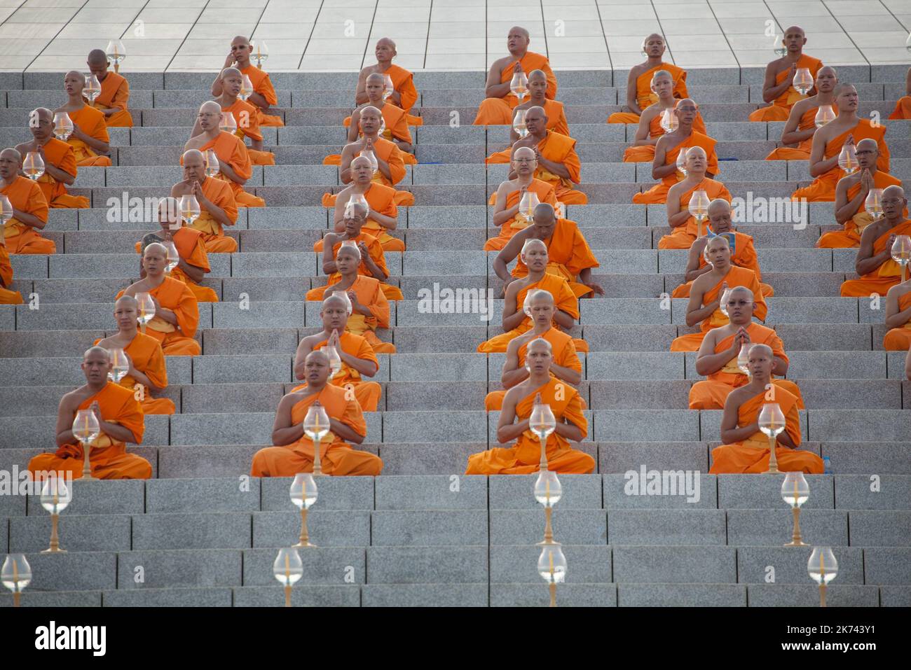 Buddhist monks pray during a yearly ceremony at Wat Phra Dhammakaya Temple in the north of Bangkok, Thailand on February 11, 2017. Thai people celebrate the buddhist festival of clockwise circumambulation and Makha pratipa lantern lighting ceremony at Dhammakaya Temple on 'Makha Bucha Day' during the third lunar moon, where around 1250 monks gathered to be ordained by the Buddha.   Stock Photo