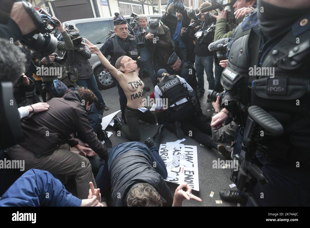Members of feminist activist group Femen protest against French presidential election candidate for the far-right Front National  party Marine Le Pen outside a polling station in Henin-Beaumont, during the first round of the Presidential election.  Stock Photo