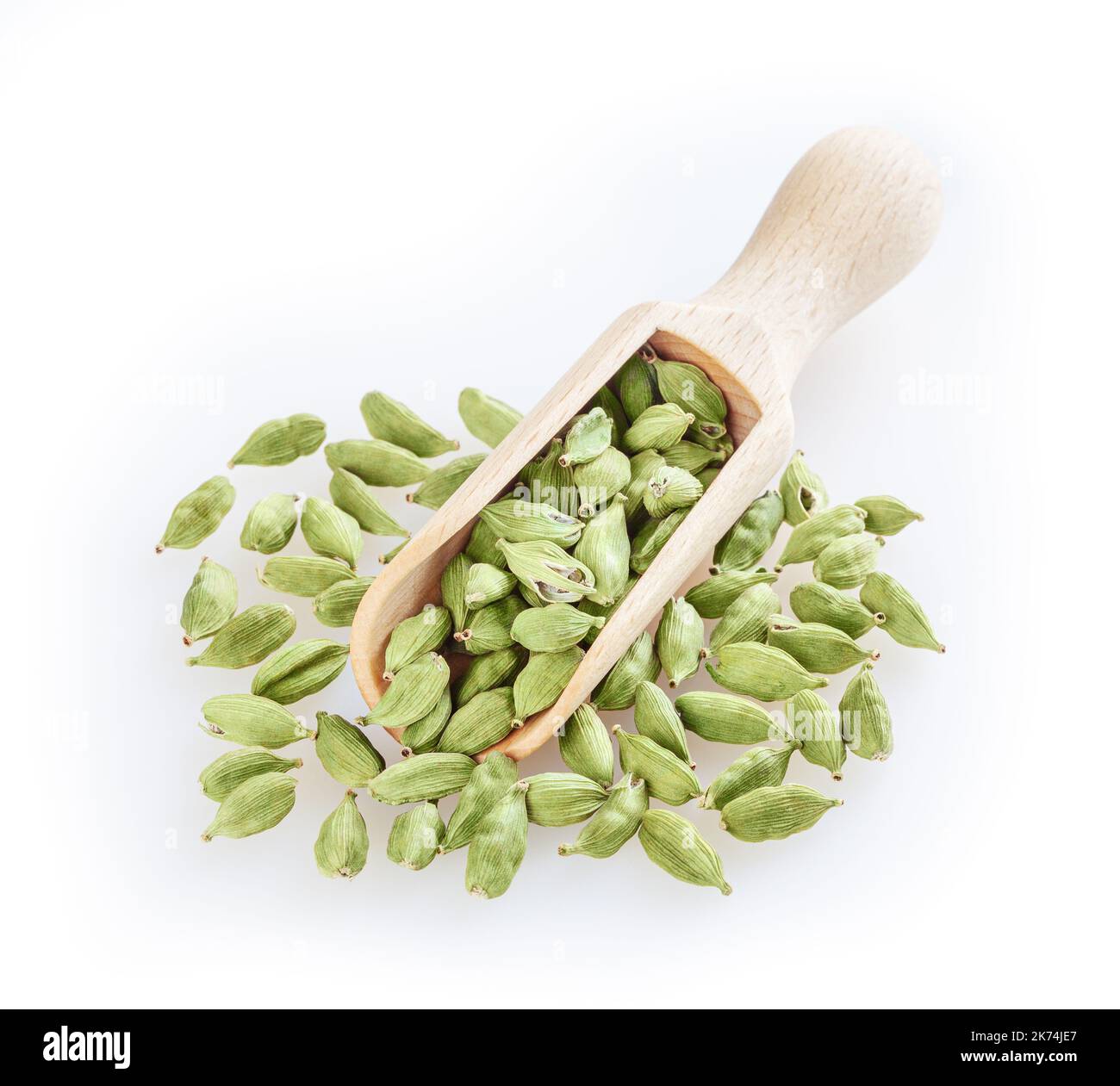 Green cardamom in wooden scoop isolated on white background Stock Photo