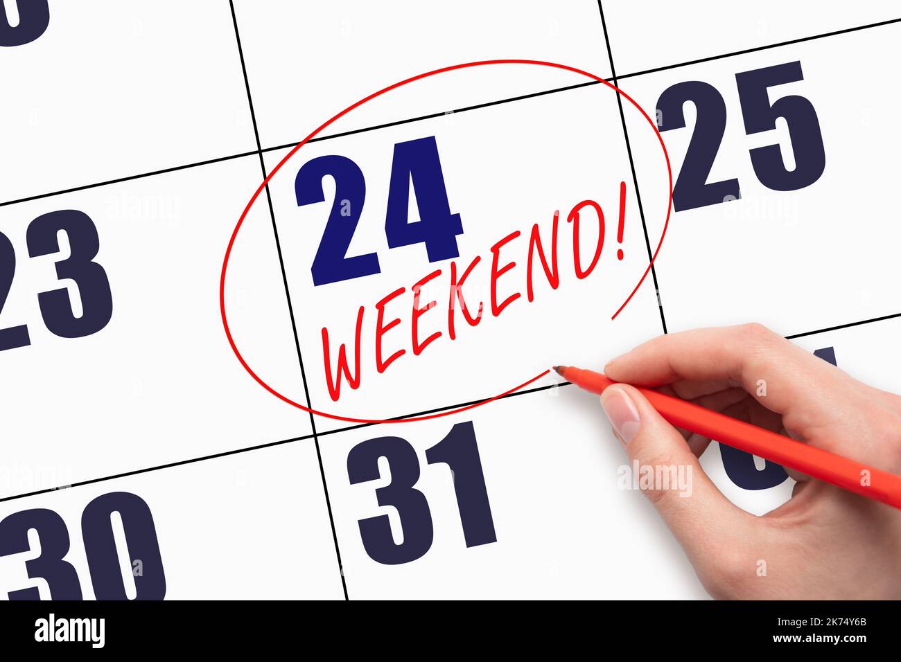 24th day of the month. Hand writing text WEEKEND and circling the ...