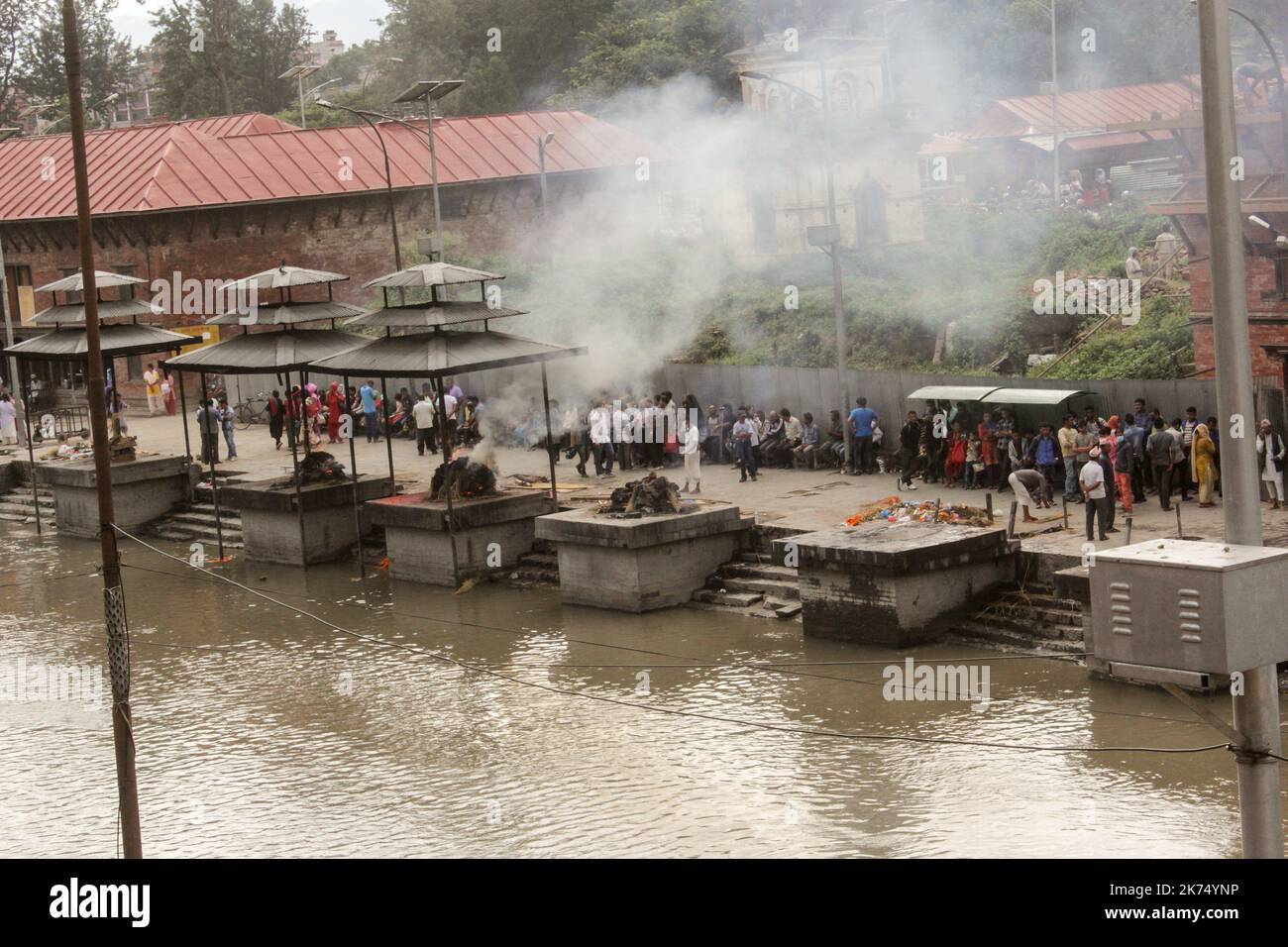 This temple is used primarily for outdoor cremation of the dead. The bodies are transported 24 hours after the death to the temple and then burned for 3 hours before seeing ashes thrown into the Bagmati River that runs through the temple. Only members of the royal family are cremated directly in front of the temple of Pashupatinath. Stock Photo