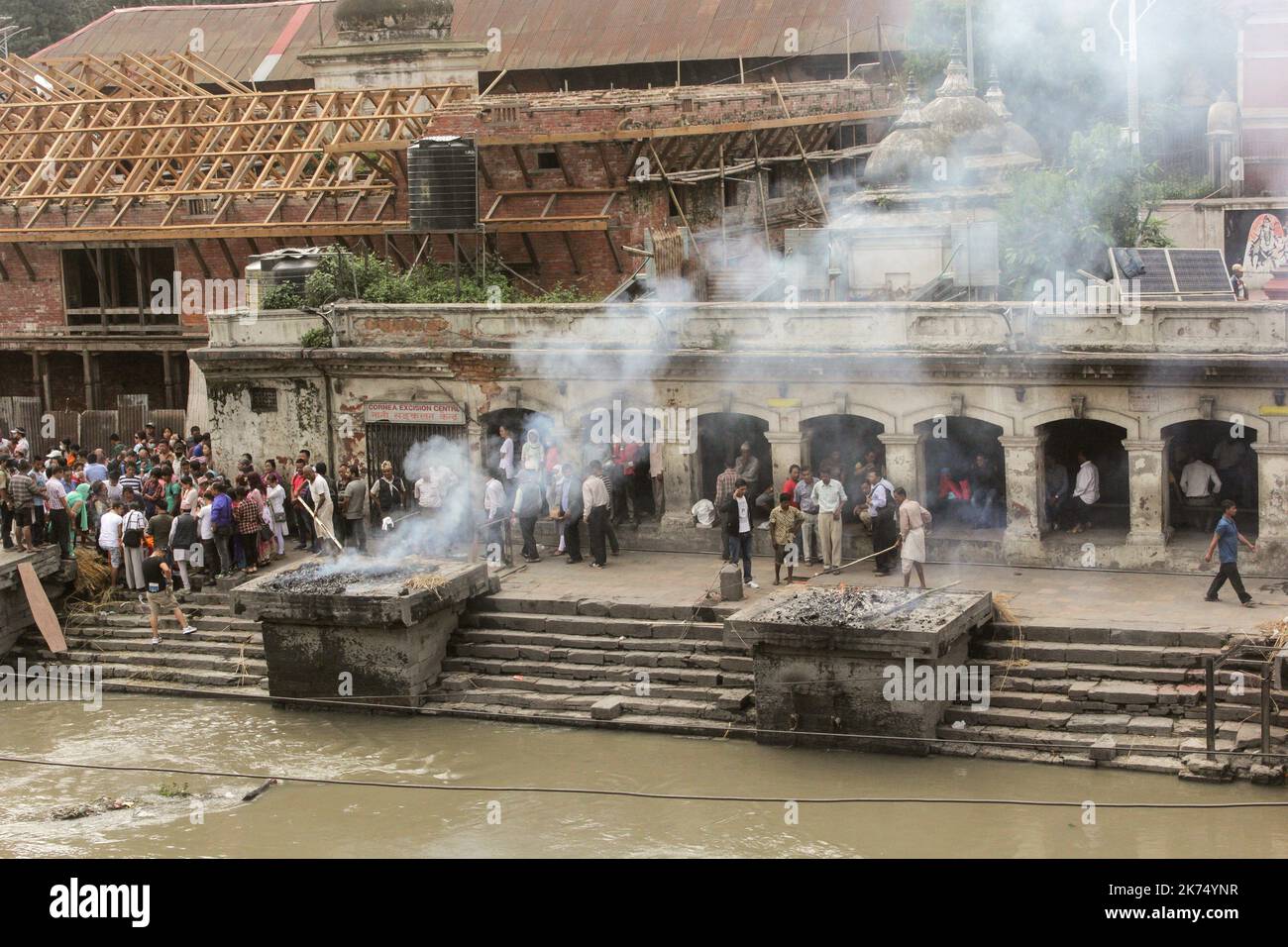 This temple is used primarily for outdoor cremation of the dead. The bodies are transported 24 hours after the death to the temple and then burned for 3 hours before seeing ashes thrown into the Bagmati River that runs through the temple. Only members of the royal family are cremated directly in front of the temple of Pashupatinath. Stock Photo
