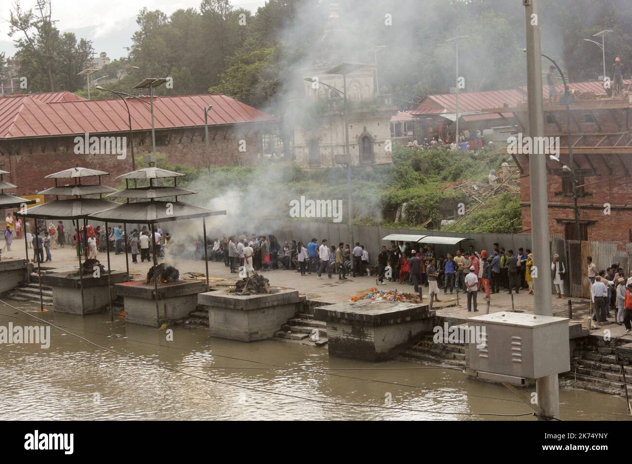 This temple is used primarily for outdoor cremation of the dead. The bodies are transported 24 hours after the death to the temple and then burned for 3 hours before seeing ashes thrown into the Bagmati River that runs through the temple. Only members of the royal family are cremated directly in front of the temple of Pashupatinath. Stock Photo