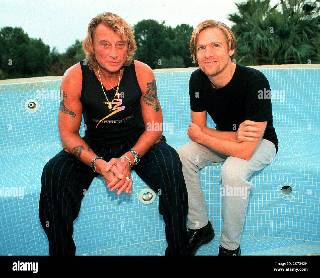 SAINT TROPEZ HALLYDAY OCTOBER 1995 WITH BRYAN ADAMS SINGER AT LAURADA      FILES - Johhny Hallyday, who became the first Gallic singer to popularize rock n' roll in France and sold over 110 million records during a music career spanning over half a century, has died. He was 74 and had been fighting cancer for several months. Widely known as the 'French Elvis,' Hallyday began his singing career at the end of the 1950s specializing in French-language cover versions of famous songs by artists like Gene Vincent, Eddie Cochrane and Elvis Presley, whose example inspired him to become a singer. Stock Photo