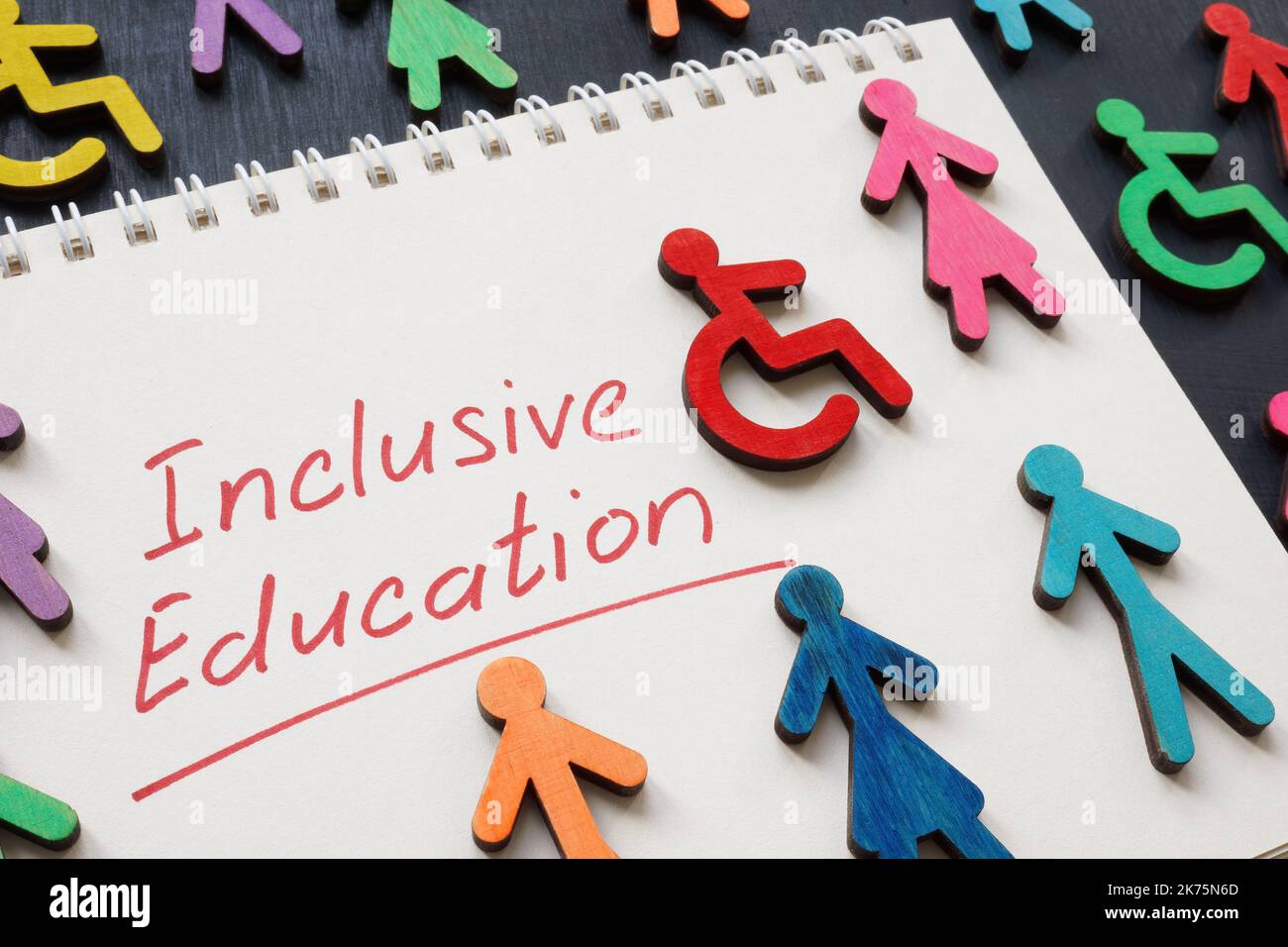 Notepad with phrase Inclusive education and colorful figures. Stock Photo