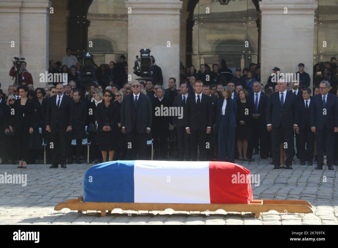 The crowd of funeral goers pay their respects whilst attending the