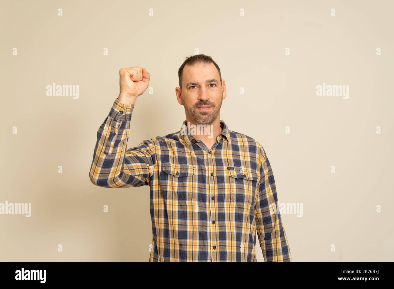 Happy successful bearded businessman winning, fist raised celebrating success isolated beige wall background. Positive human emotion facial expression Stock Photo