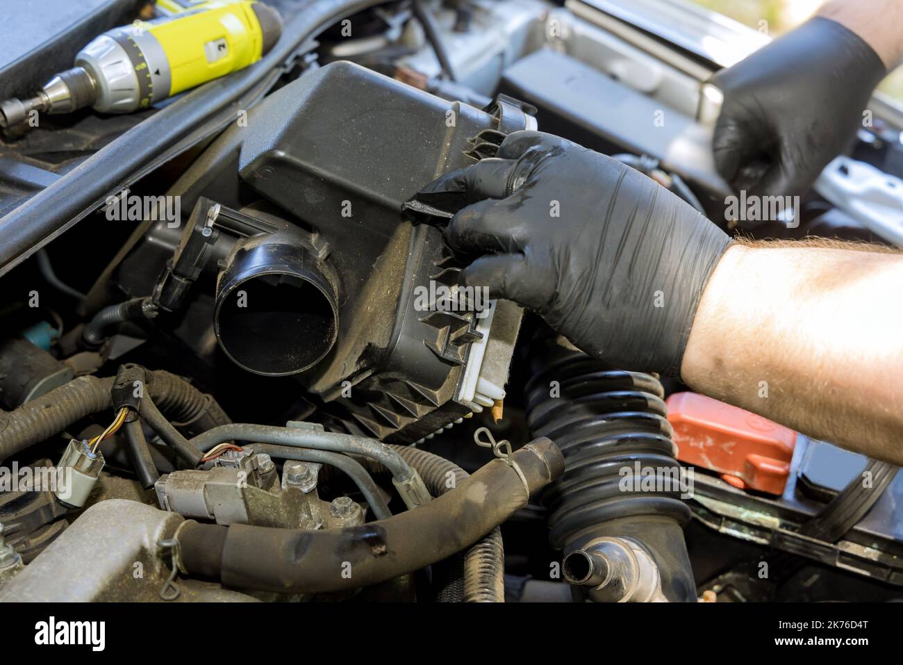 Mechanic hand is replacement car air filter into car engine in service