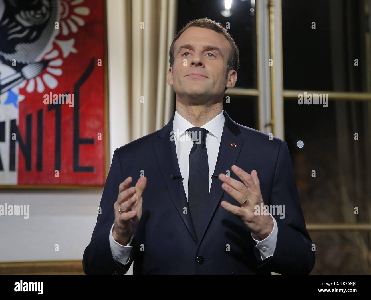 French President Emmanuel Macron, gestures as he poses for a photograph after the recording of his New Year's speech at at the Elysee Palace, in Paris, Monday, Dec. 31, 2018.   Stock Photo